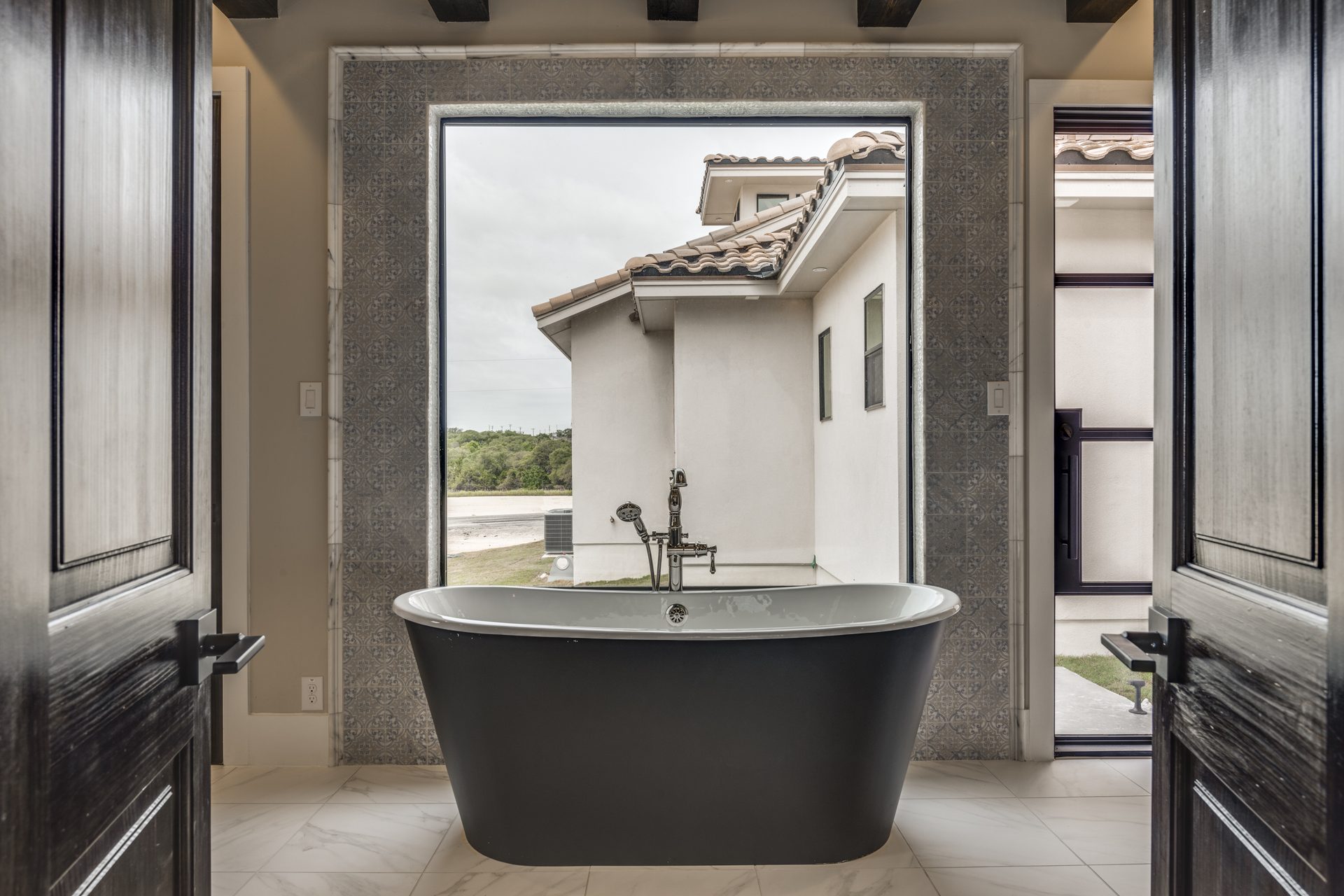 A custom Texas bathroom with a freestanding tub framed by a picture window